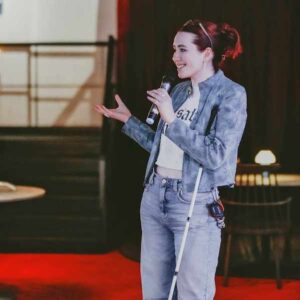 Image of woman with a microphone addressing an event.